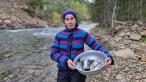 A WOMAN LIVES IN THE MOUNTAINS. COOKING TROUT FISH
